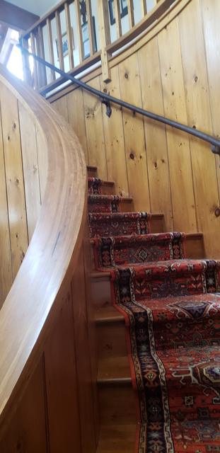 Curved staircase, natural wood finish by Jewell Painting