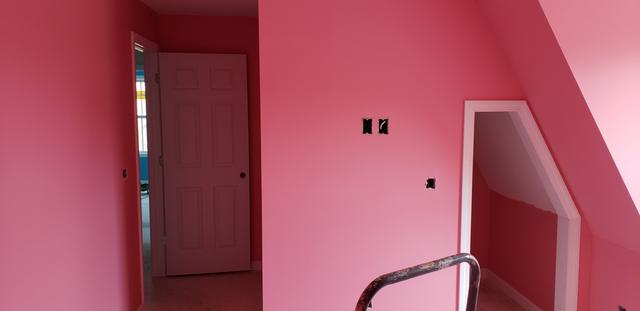 Pink bedroom with an angled ceiling by Jewell Painting